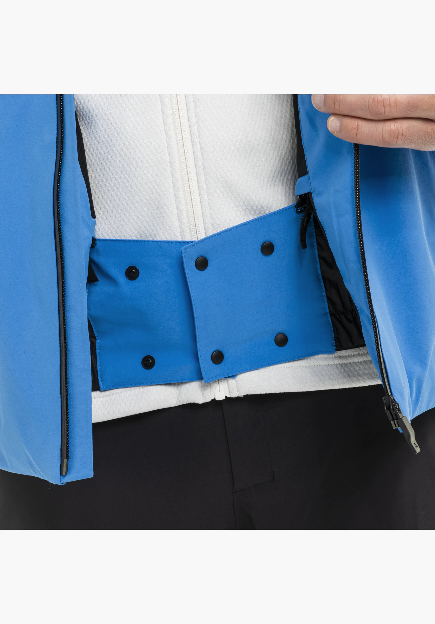 Jacket Style Pontre MEN featuring an integrated powder skirt in blue with snap buttons on the inside of the open jacket with white fleece lining in a close-up against a neutral background.