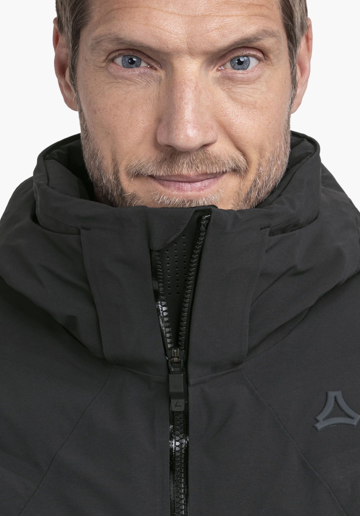 Jacket Style Radiana MEN in black, worn by a male model in an upright stance in a side view with a closed hood and visible Schöffel logo against a white background. (AI-generated)