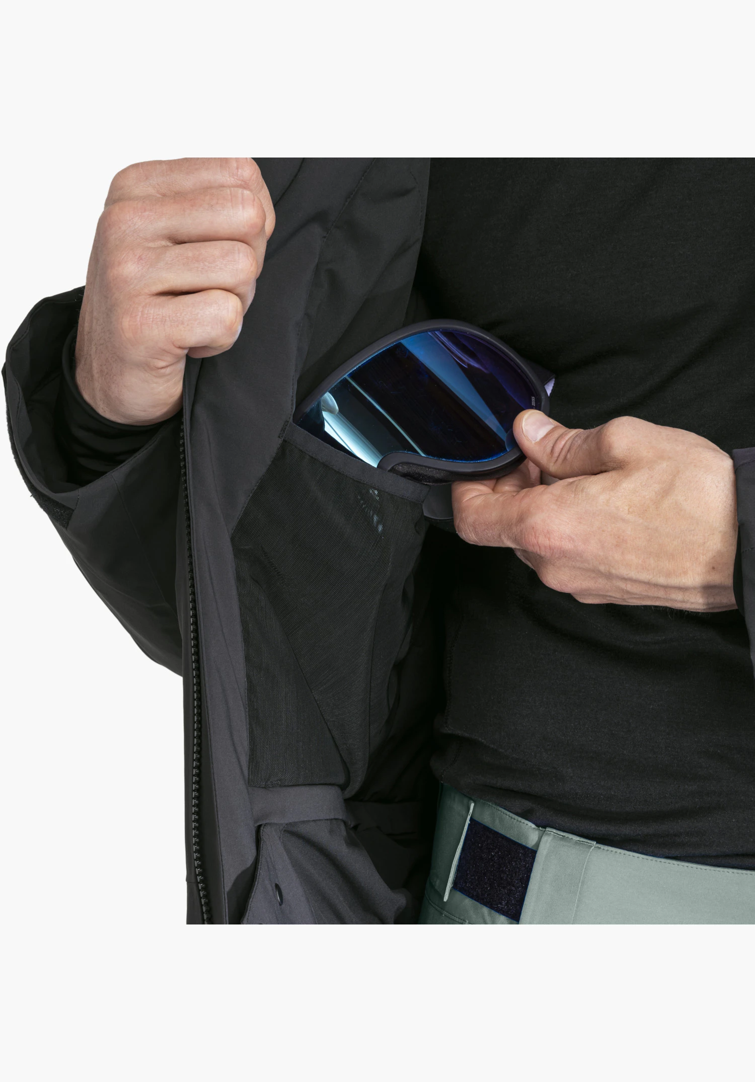 Jacket Style Radiana MEN in black showing the practical inner pocket with ski goggles against a neutral background. Close-up against a neutral background.