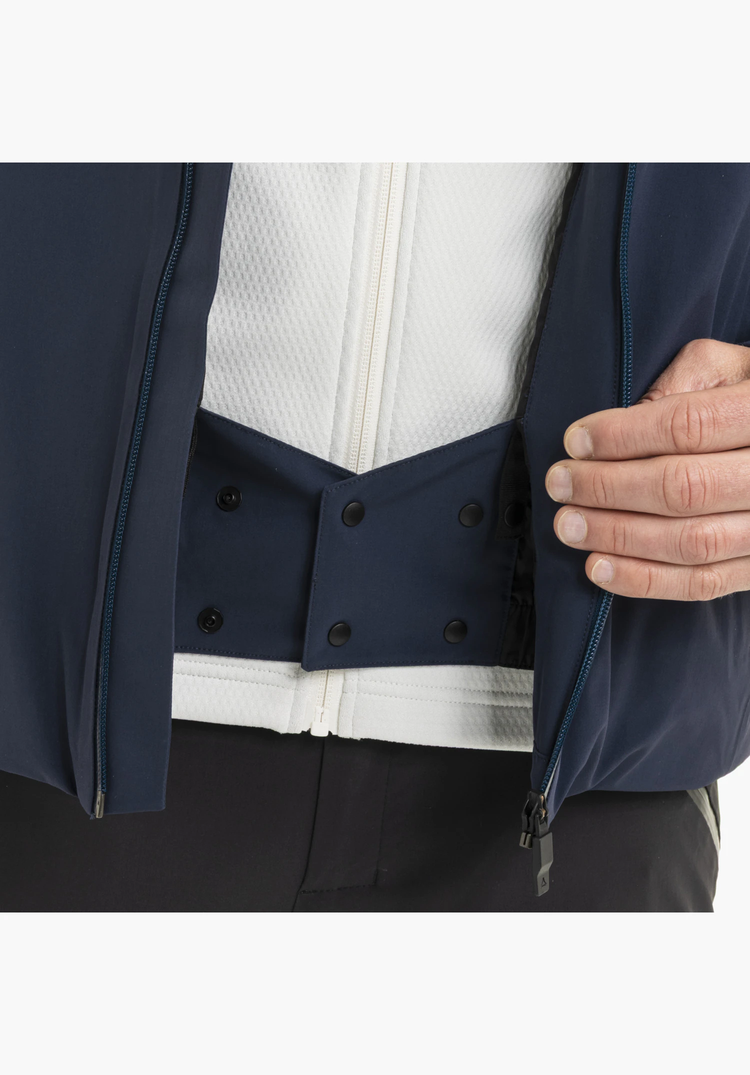 Jacket Style Safuna MEN featuring an integrated snow skirt in blue with snap buttons and a zipper in the interior close-up shot against a white background.
