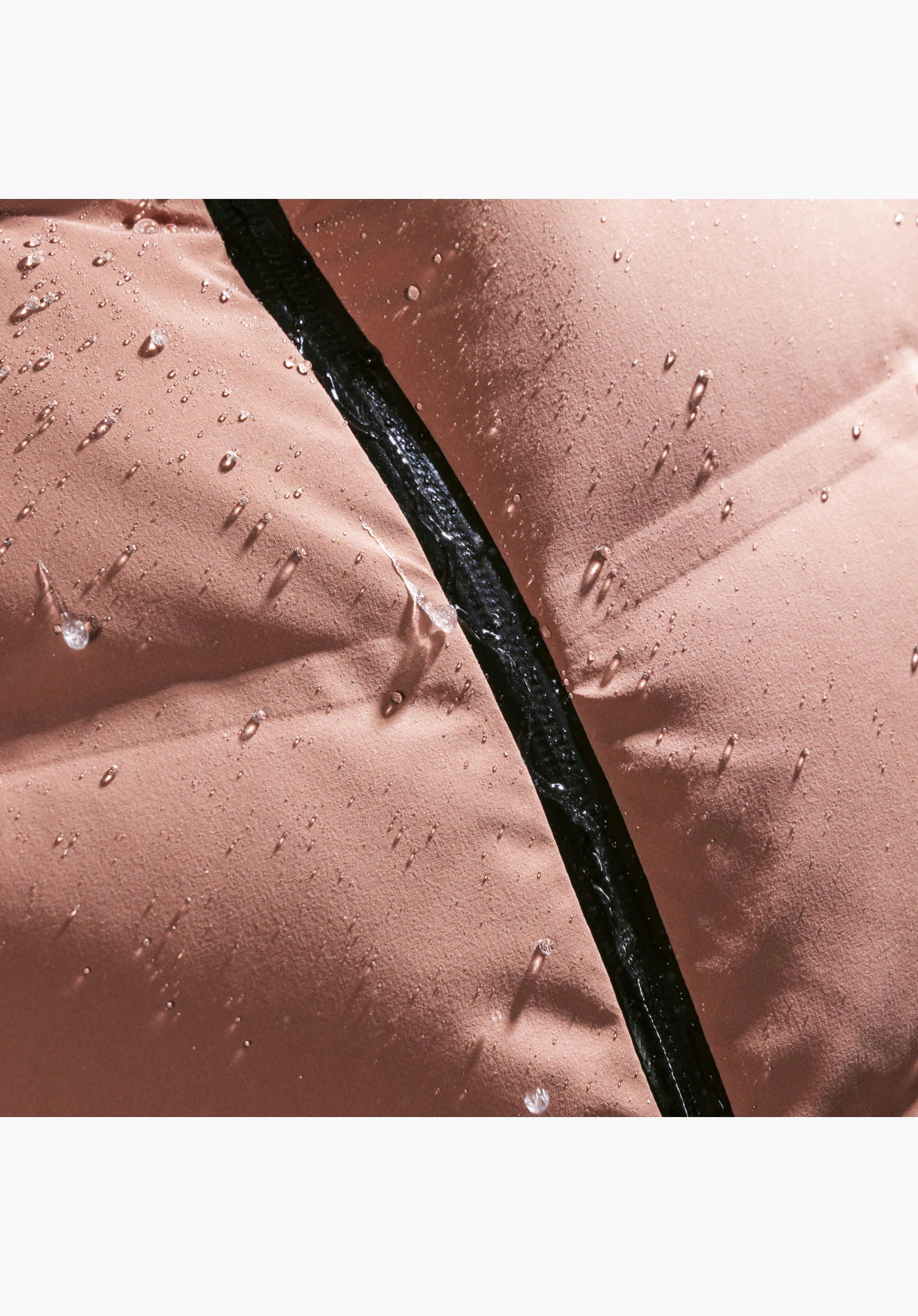 Jacket Style Caldirola WMN en rose avec des gouttes d'eau perlants sur la structure du tissu déperlant et la fermeture éclair thermosoudée, gros plan sur fond blanc.