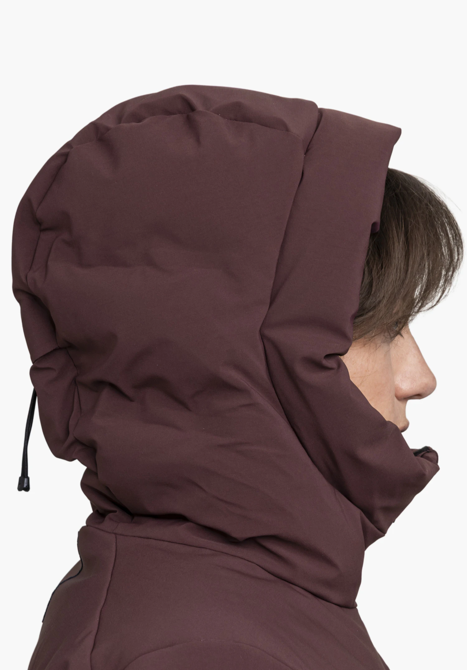 Jacket Style Radiana WMN en violet, porté de profil par un mannequin femme se tenant debout, capuche fermée, sur fond blanc. (Généré par IA)