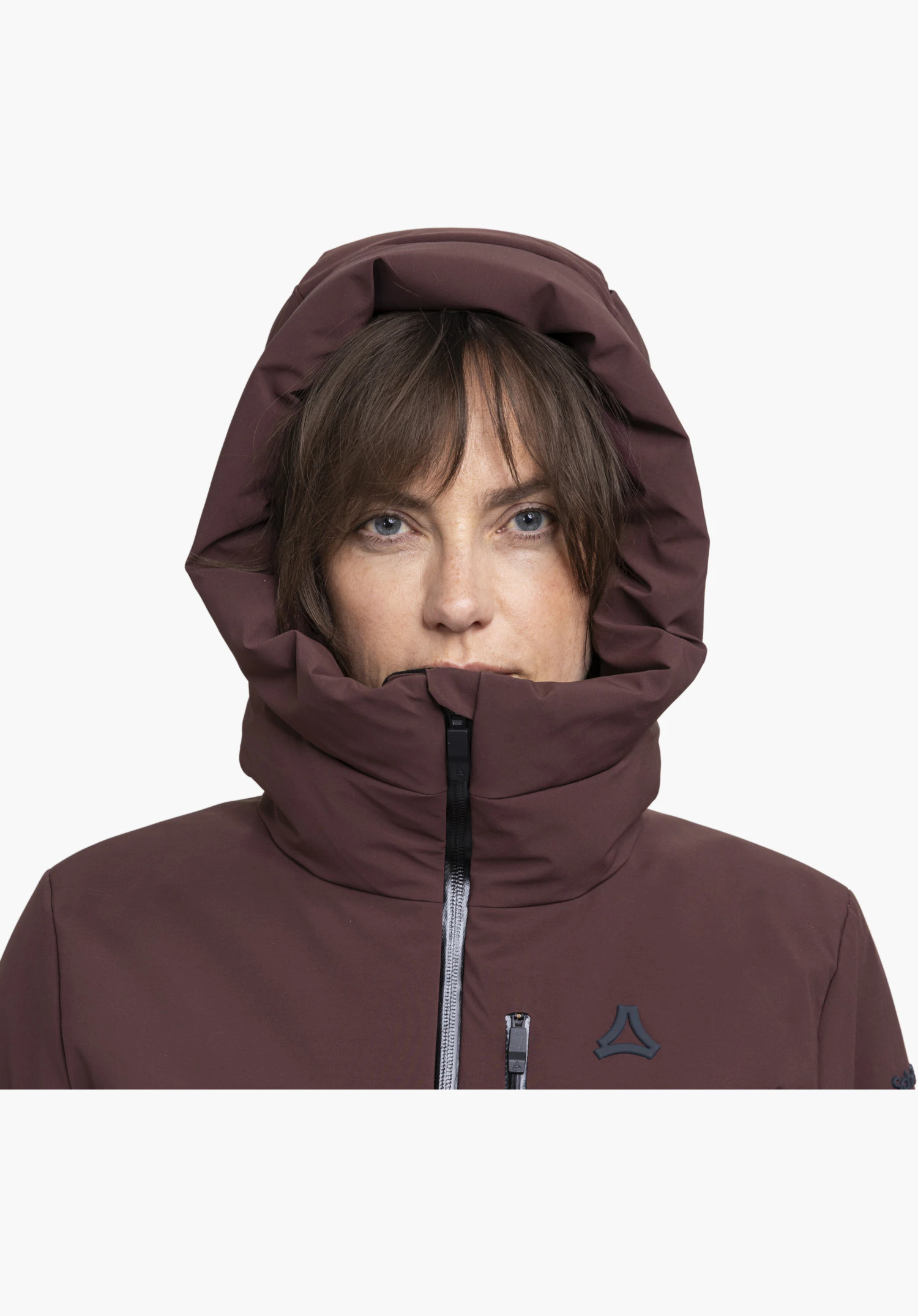 Jacket Style Radiana WMN montre la capuchon et le col montant en violet avec le logo Schöffel et une fermeture éclair en gros plan sur fond blanc.