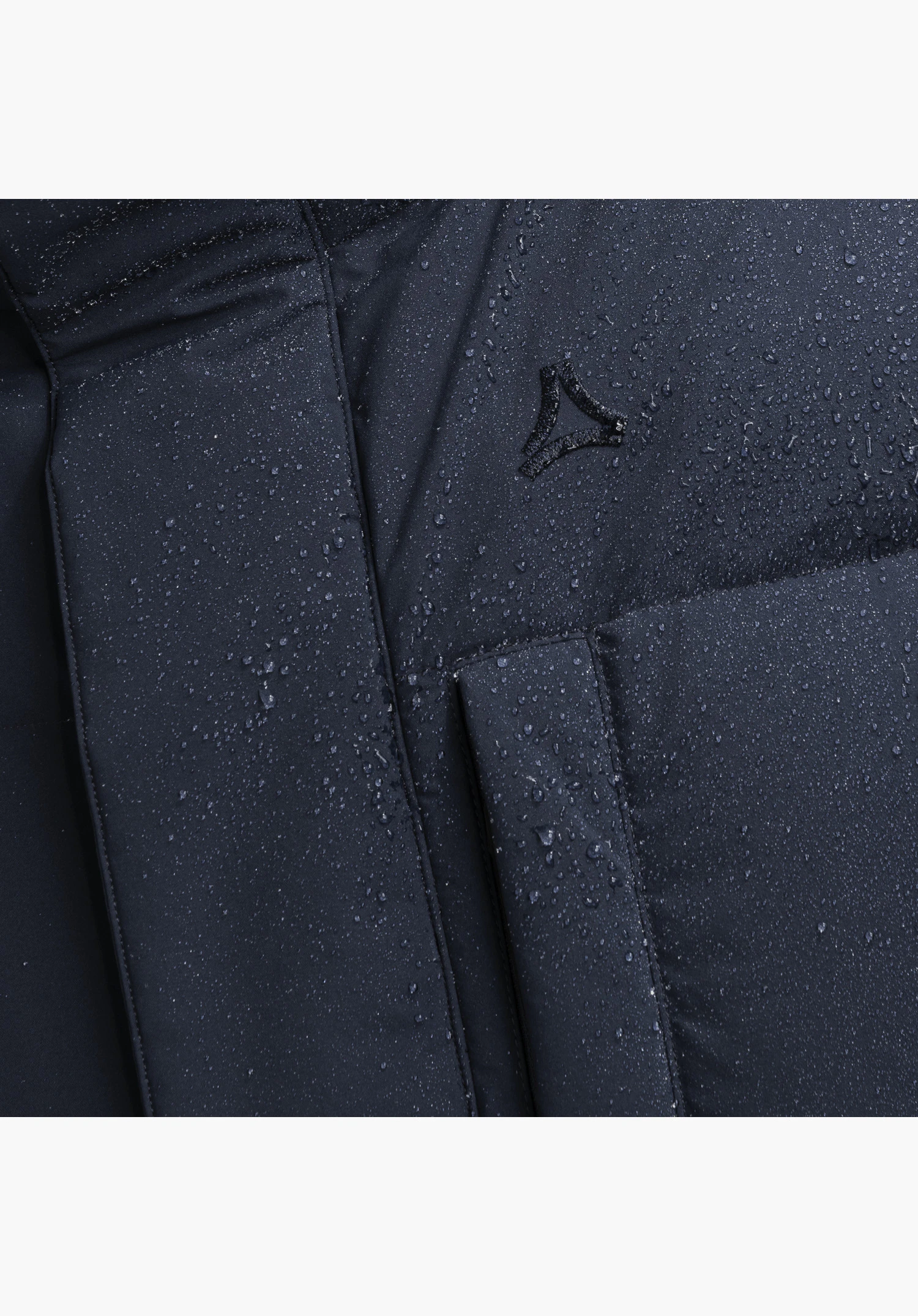 Down Parka Style Vindave MEN in blue with blue water droplets on the water-repellent material structure, showing the tonal Schöffel logo and a patch pocket close-up against a white background.