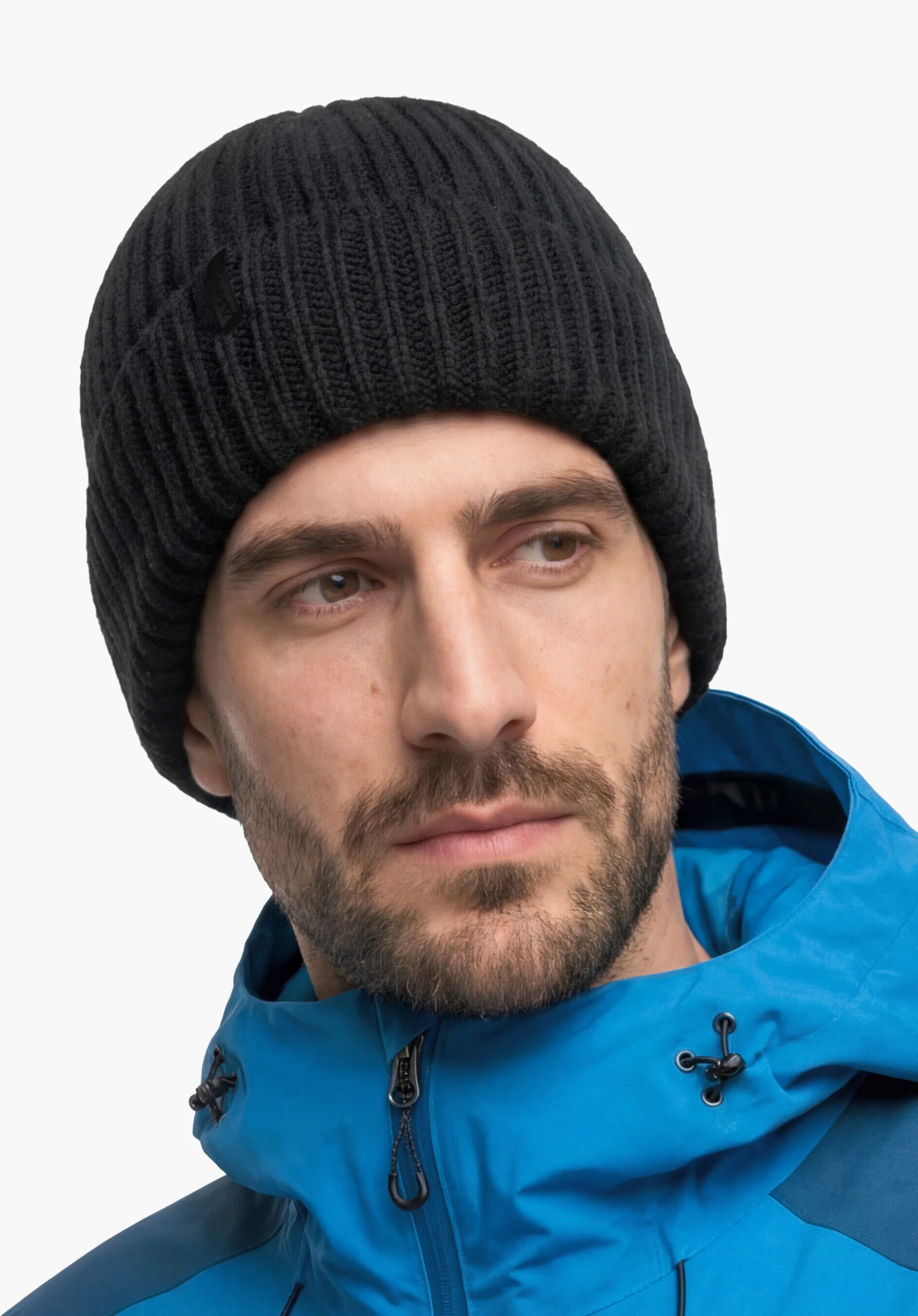 Knitted Hat Medford in black featuring the Schöffel logo, worn by a male model with his head slightly turned in a rear view against a white background. (AI-generated)